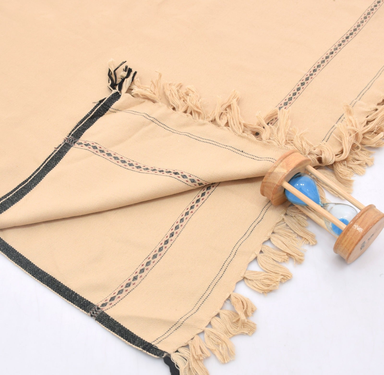 Beige Wool Shawl with tassels and a wooden hourglass on a white background