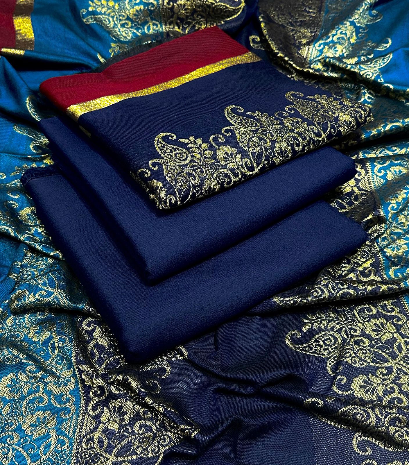 Blue fabric with gold embroidery on a blue and gold patterned background