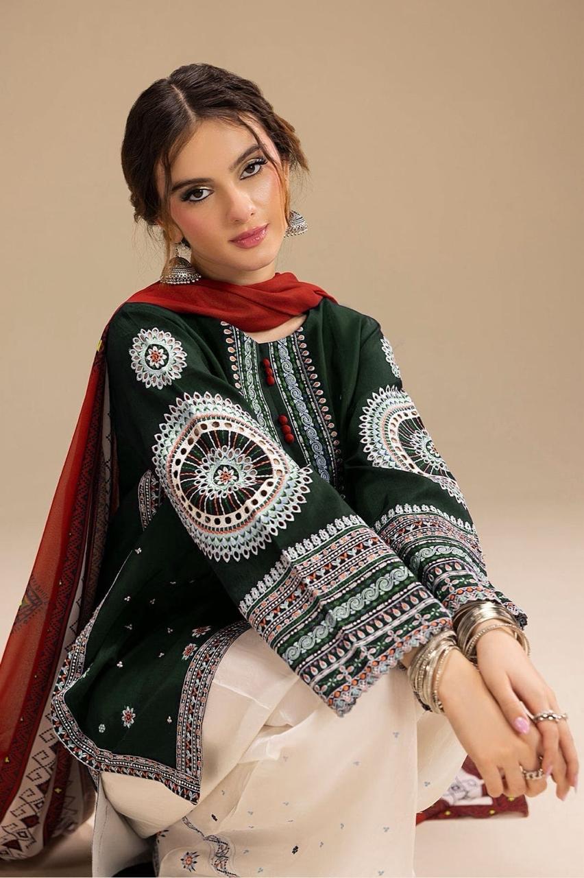 Woman wearing a dark green embroidered traditional outfit with a red scarf on a beige background.Elegant Pakistani winter 3pc suit in linen fabric