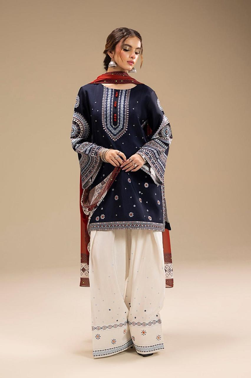 Woman wearing a navy blue embroidered top and white pants with a red dupatta on a beige background.Elegant Pakistani winter 3pc suit in linen fabric