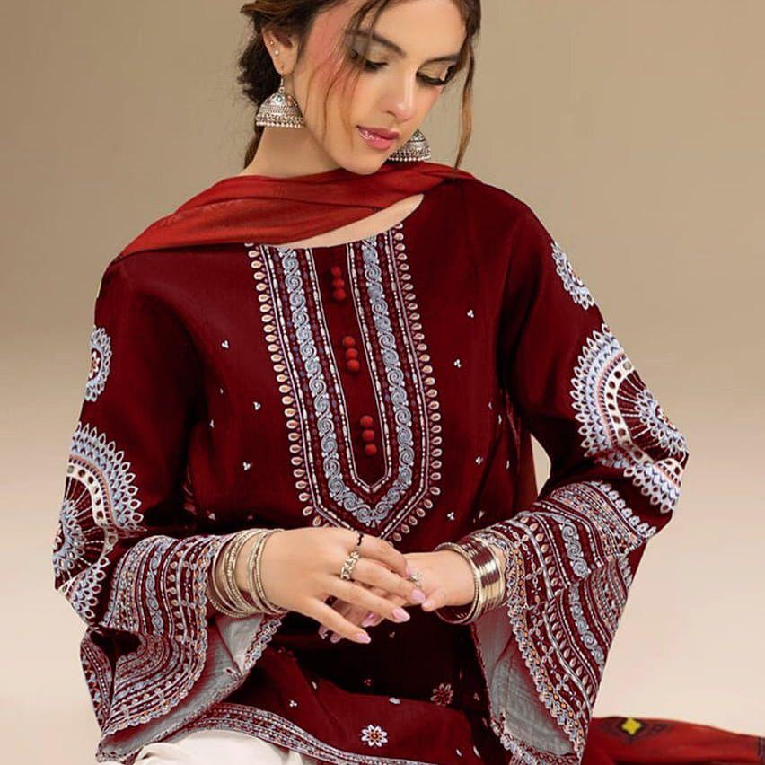 Woman wearing a maroon embroidered traditional outfit with a beige background.
Elegant Pakistani winter 3pc suit in linen fabric