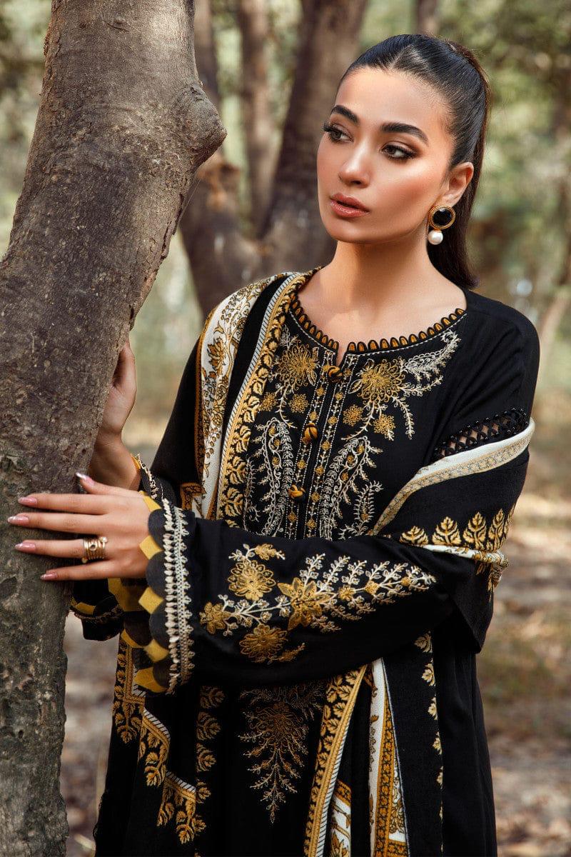 Woman in a black and gold embroidered outfit standing in a forest.
Elegant Pakistani winter 3pc suit in linen fabric
