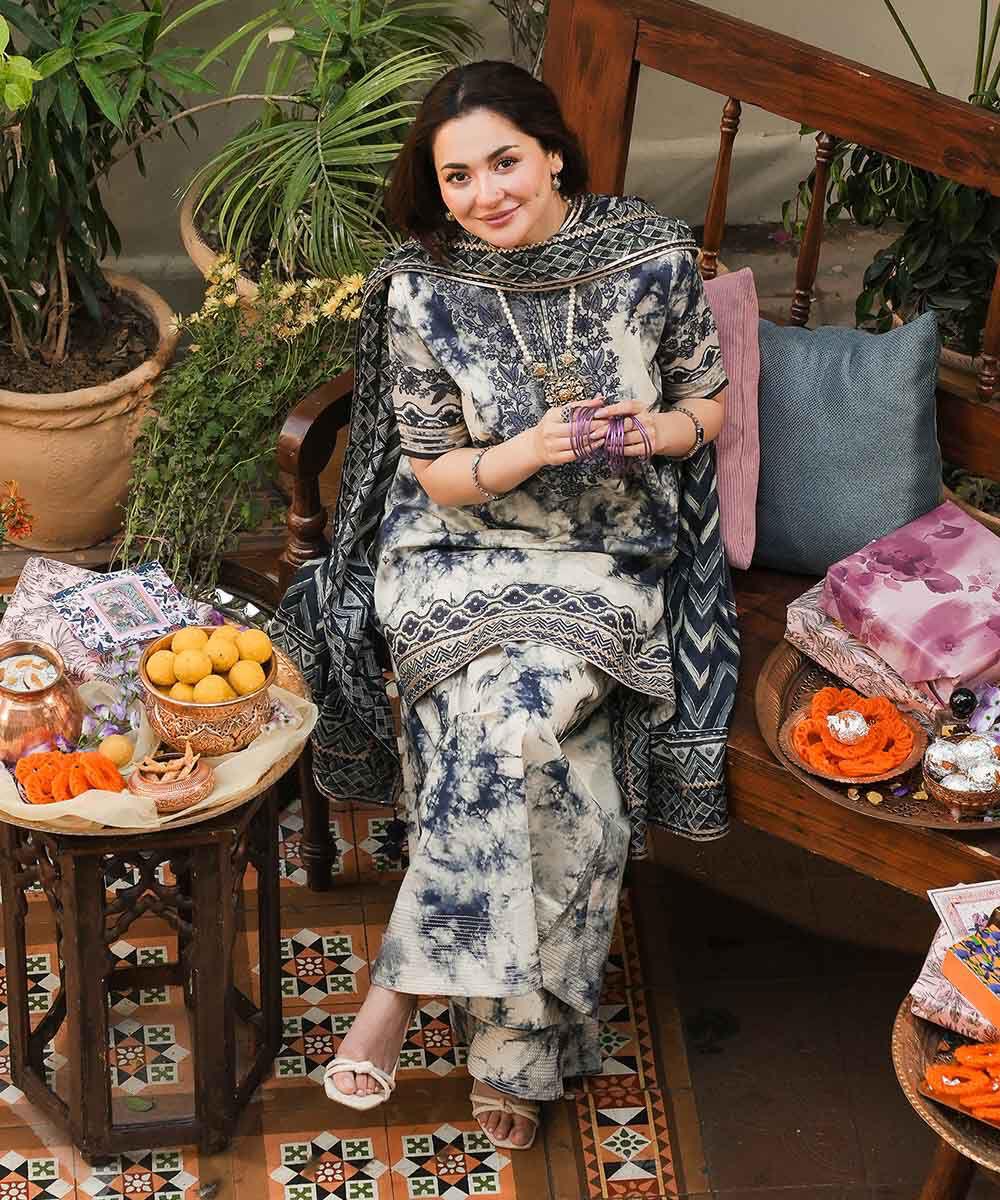 Woman in a patterned outfit sitting in a decorative room with plants and furniture.
Elegant Pakistani winter 3pc suit in linen fabric