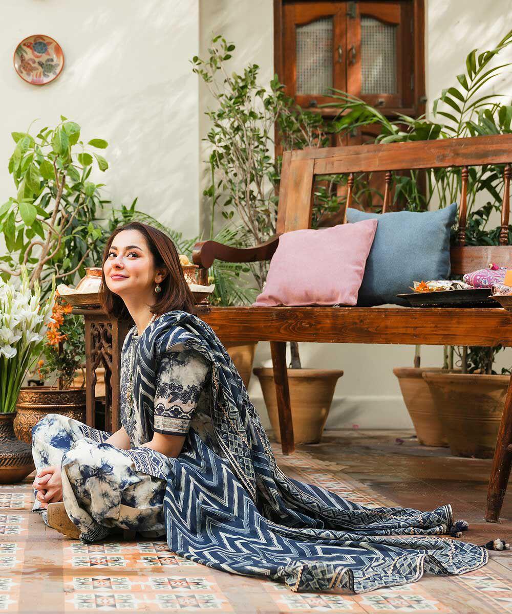 Woman sitting on a wooden floor in a room with plants and a wooden bench.
Elegant Pakistani winter 3pc suit in linen fabric
