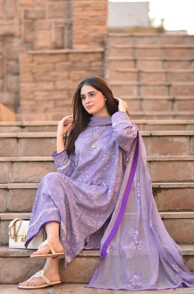 Woman in a purple traditional outfit sitting on stone steps.
Elegant Pakistani winter 3pc suit in linen fabric