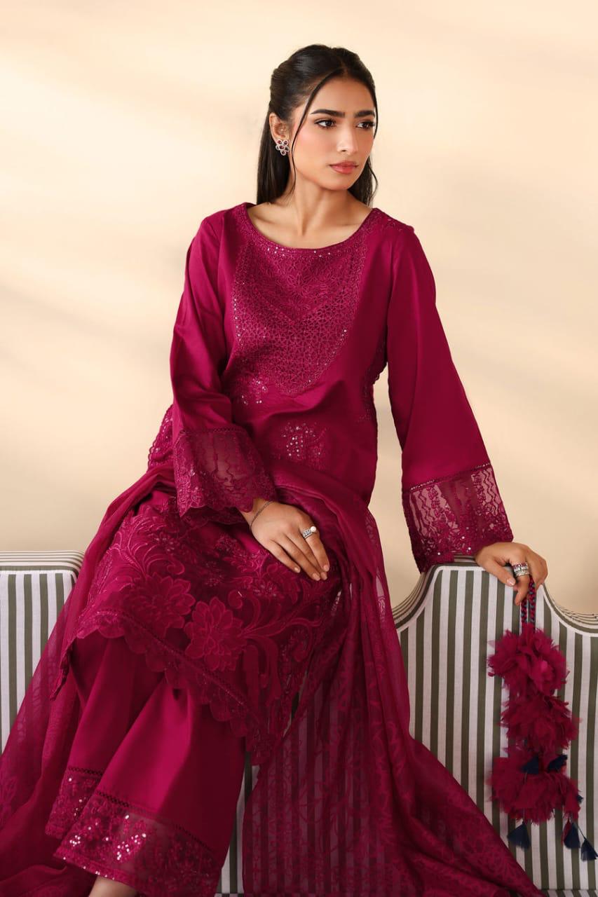 Woman wearing a maroon traditional outfit with intricate designs on a beige background.
Elegant Pakistani winter 3pc suit in linen fabric
